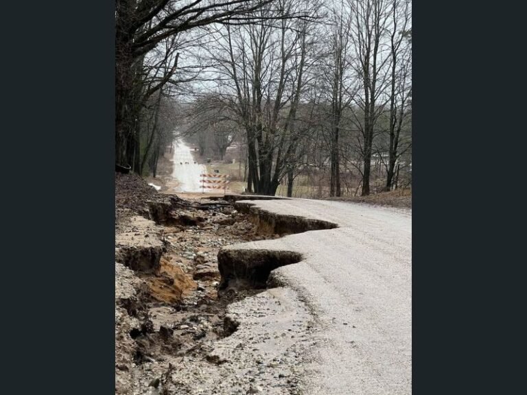 After Heavy Rain: Washed-Out Road in Greenwood Township Shows Dangerous Flood Impact as Water Erodes Pavement and Forces Closures